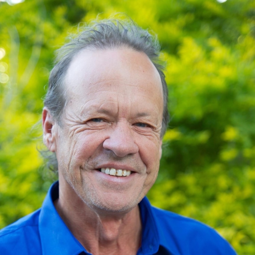 A smiling man with greying hair.