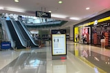 Near-empty mall and sign of coronavirus information at Westfield Garden City shopping centre in Brisbane.