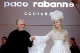 Paco Rabanne (left) walks model wearing his design down the runway.