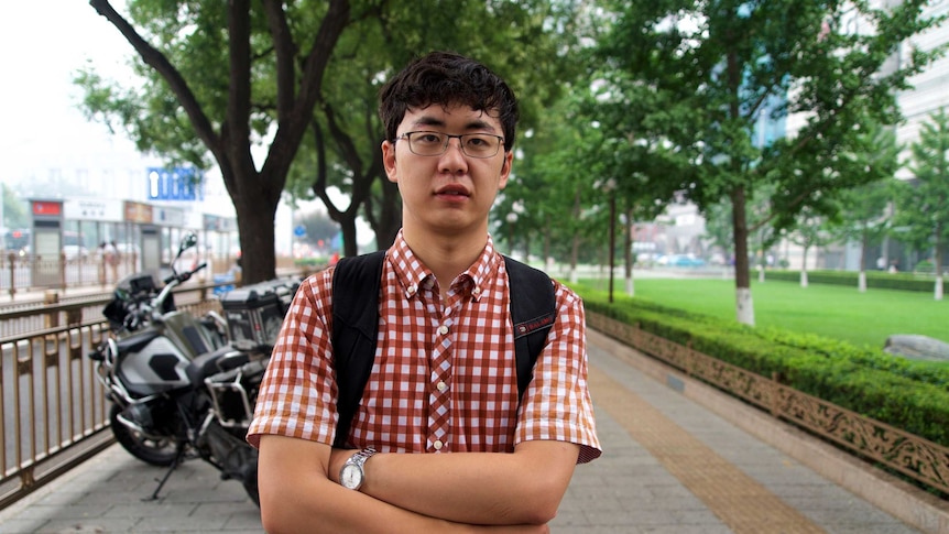 Liang Xin folds his arms and looks stern.