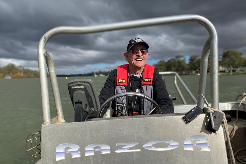 A man driving a small boat on the Murray River.