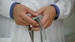 A doctor holding a stethoscope in his hands