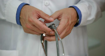 A doctor holding a stethoscope in his hands