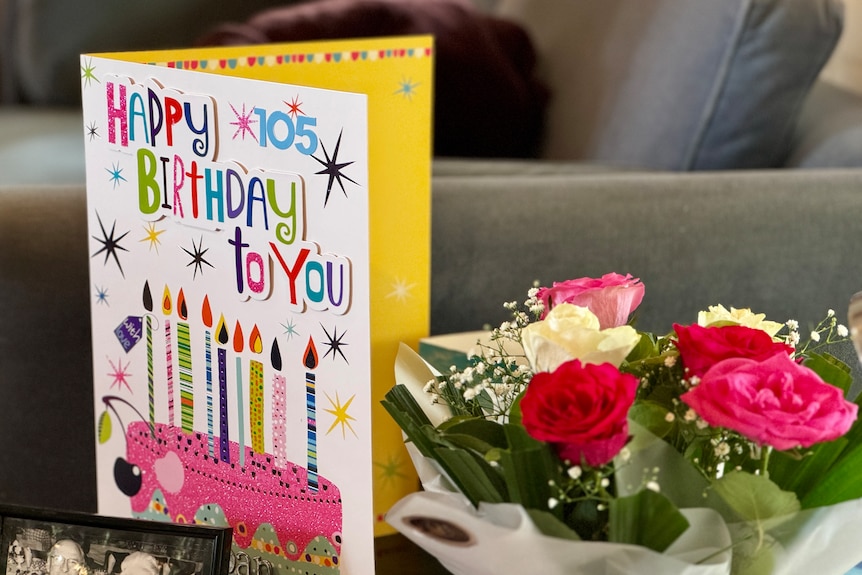 Birthday card and flowers on table