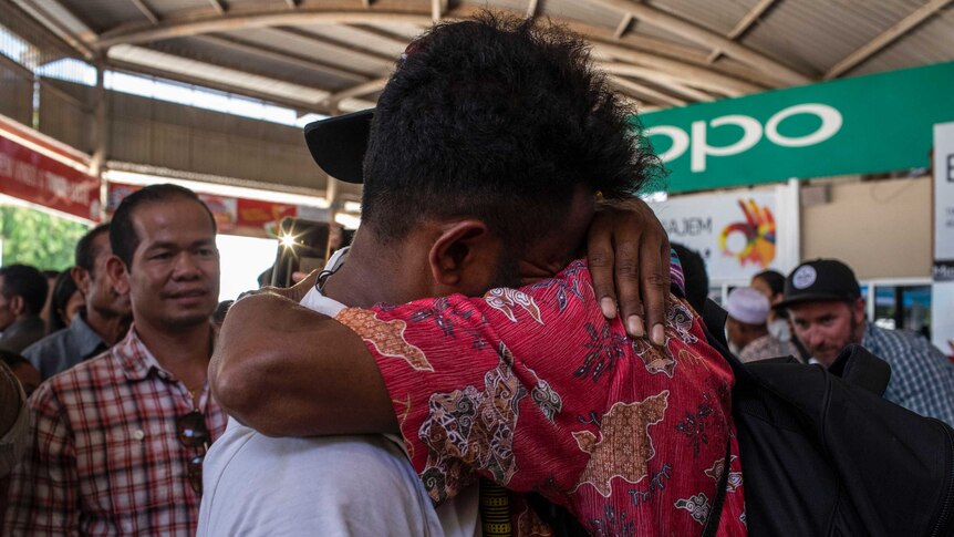 A man hugs a relative.