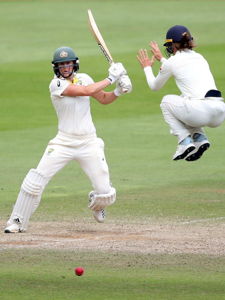 Amy Jones jumps into the air to avoid a Ellyse Perry shot.