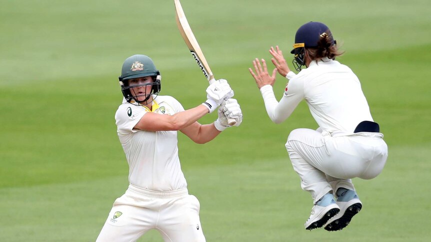 Amy Jones jumps into the air to avoid an Ellyse Perry shot.