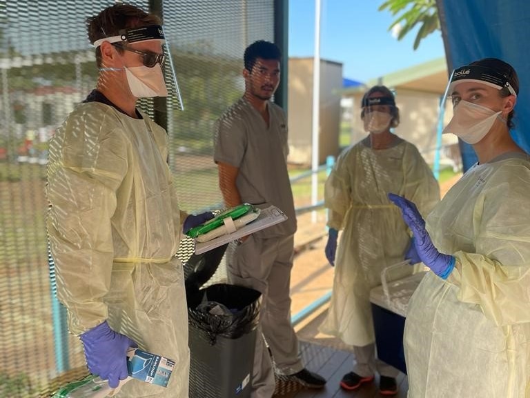 NT Health staff wearing PPE on the balcony of a donga.