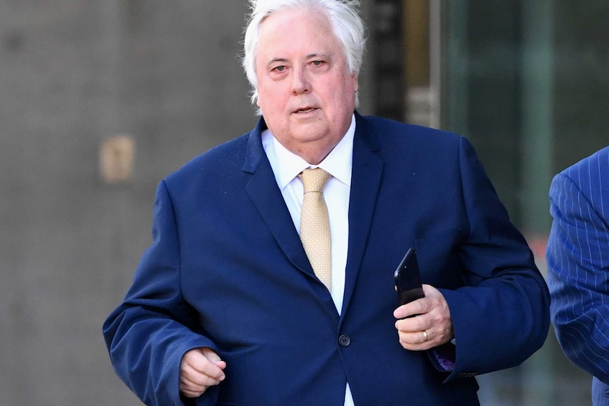 Clive Palmer walks outside of the Brisbane Supreme Court.