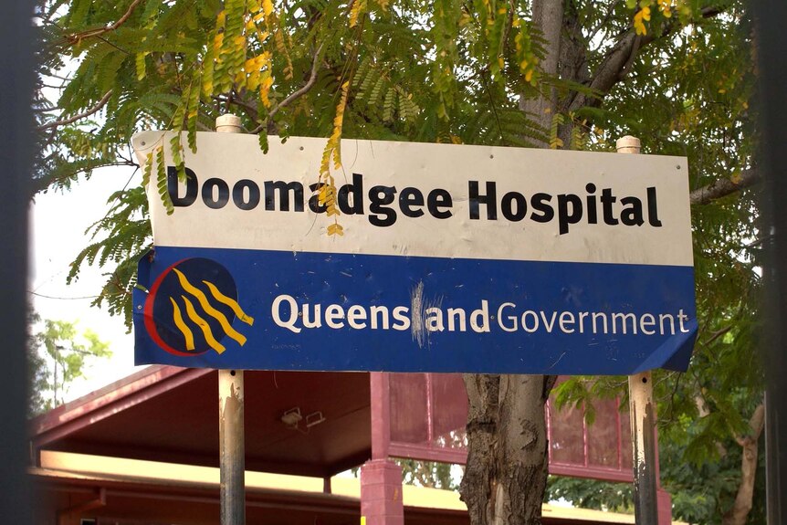A sign outside Doomadgee Hospital which says 'Doomadgee Hospital, Queensland Government'.