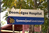 A sign outside Doomadgee Hospital which says 'Doomadgee Hospital, Queensland Government'.