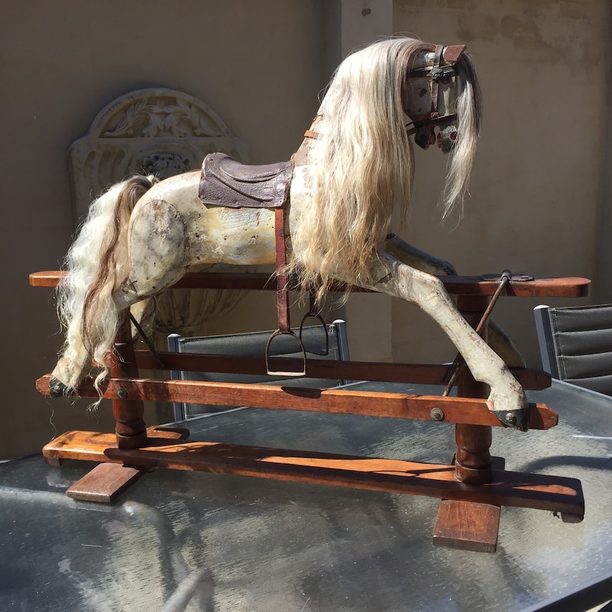 A white rocking horse with a long mane.