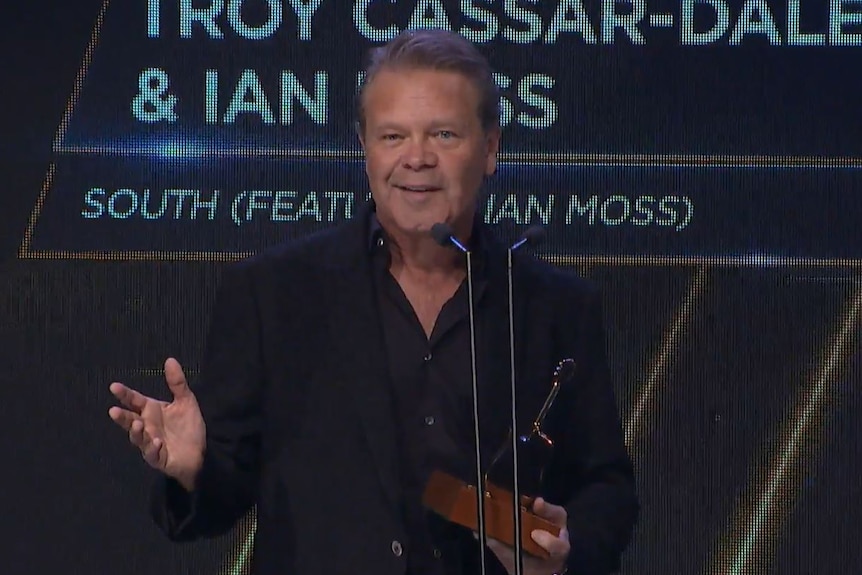 Troy Cassar Daley on stage, accepting an award.