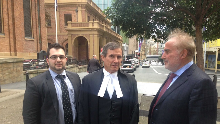 Barrister Barrister Ian Coleman SC (Centre), stands outside of the Federal Court in Sydney with his clients.