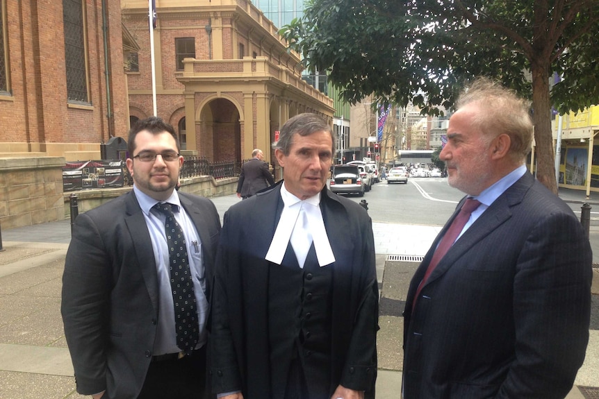 Barrister Barrister Ian Coleman SC (Centre), stands outside of the Federal Court in Sydney with his clients.