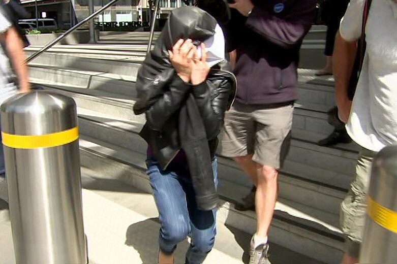 A woman charged over a hit and run in Melbourne leaves court with her face covered with a coat.