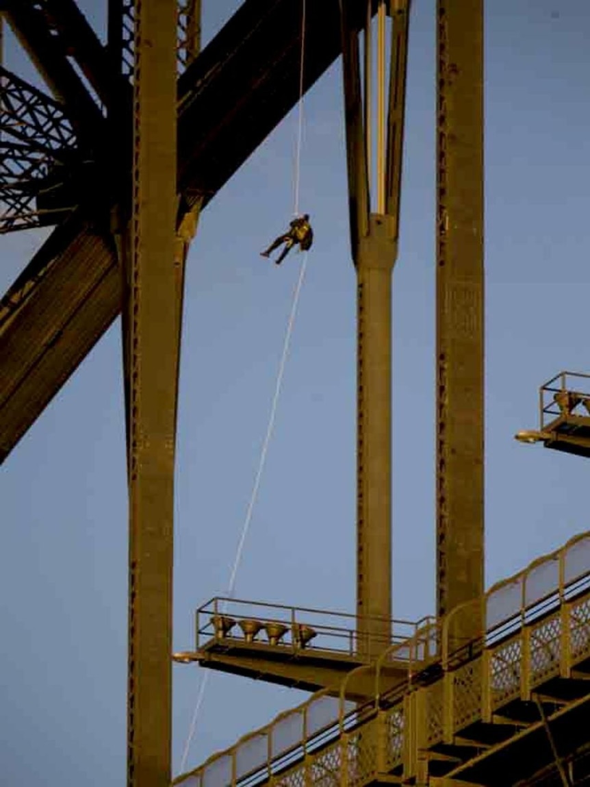 A protester abseils down from atop the Sydney Harbour Bridge