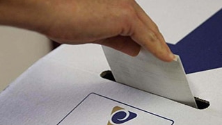 hand placing a vote in a ballot box
