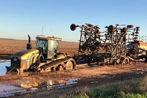 Farm machinery stuck in wet mud