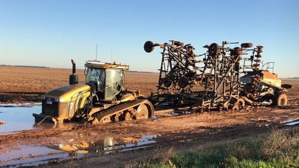 Farm machinery stuck in wet mud