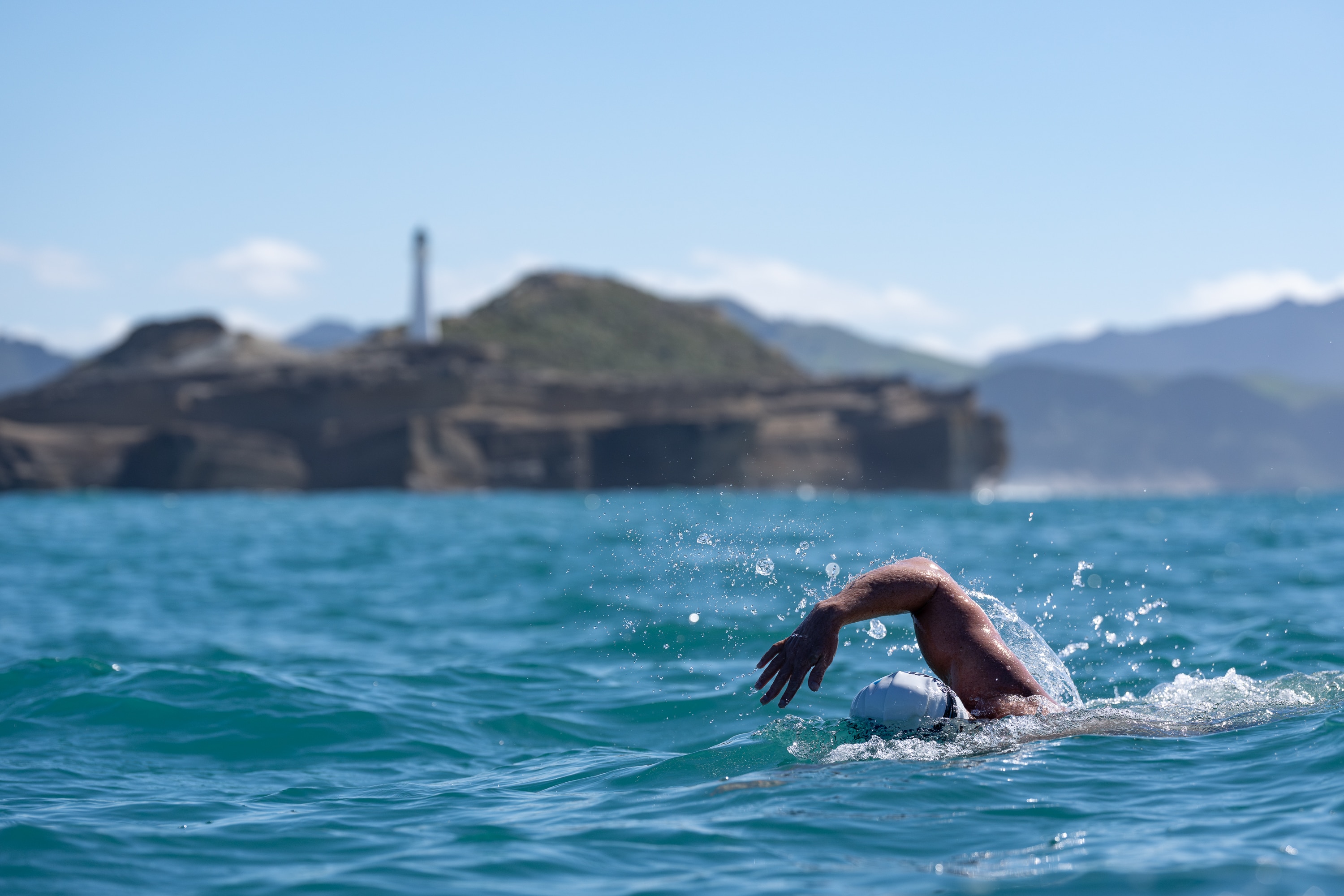 Jono Ridler swims past a lighthouse