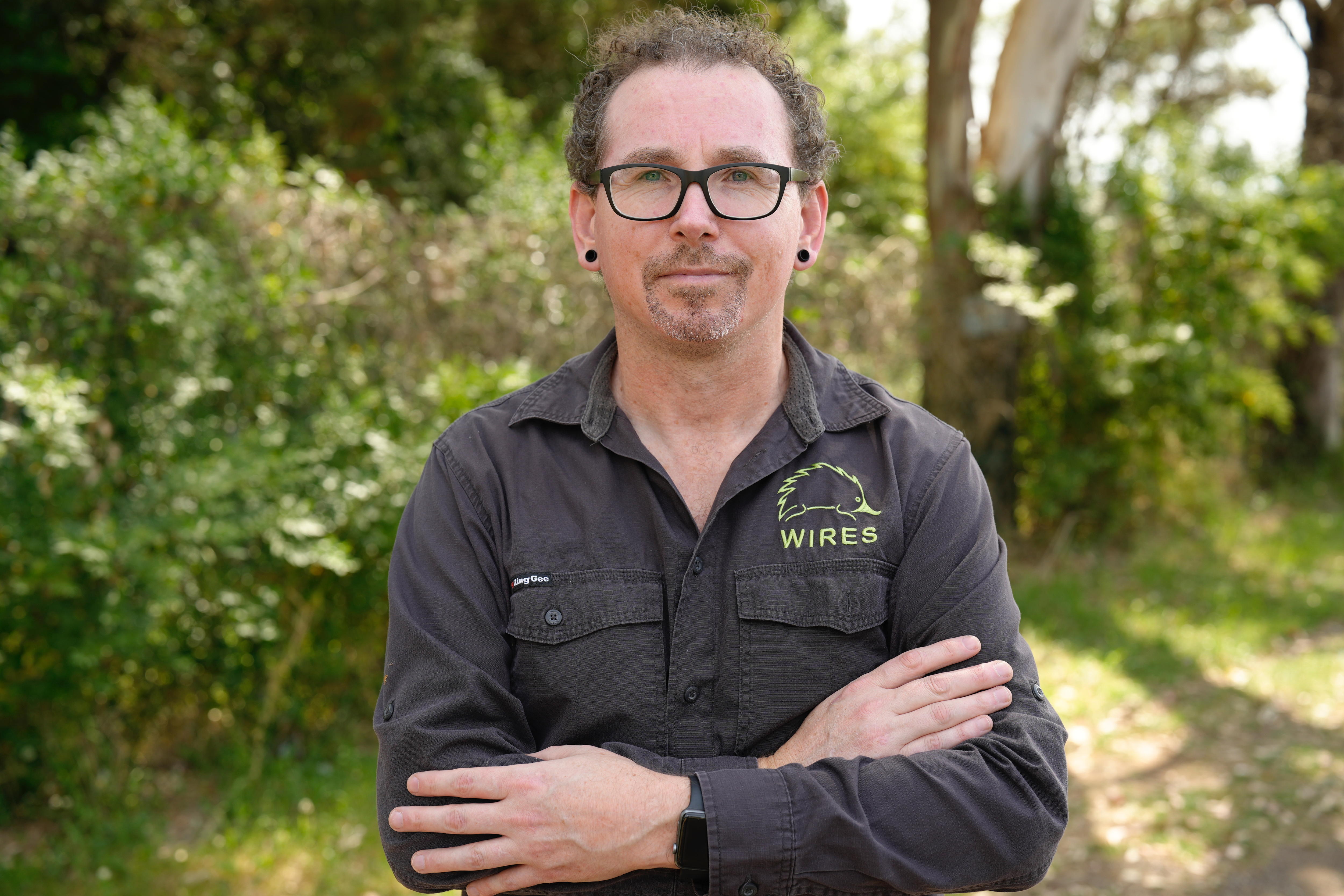 Man with curly hair, glasses in black shirt with WIRES logo