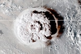 A satellite image shows an enormous cloud of volcanic dust spreading across a vast ocean.