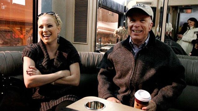 Meghan McCain and her father, senator John McCain, are pictured sitting in a booth in a restaurant.
