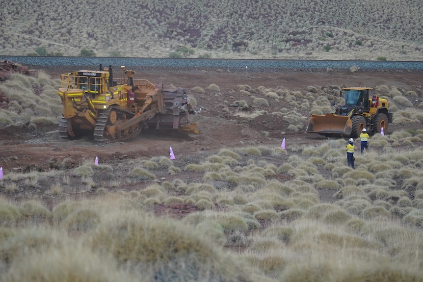 A bulldozer and digger at a train derailment site in Western Australia's Pilbara region.