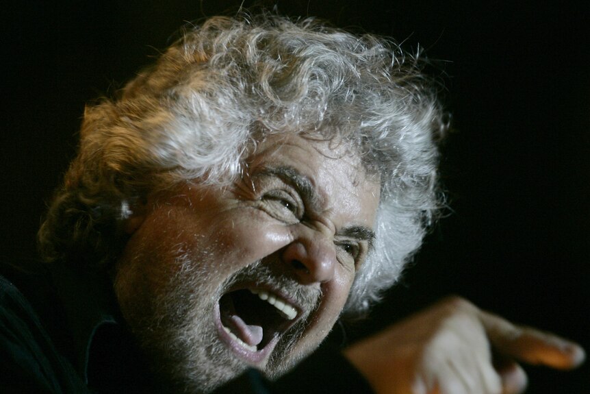 Italian showman Beppe Grillo waves to supporters during an election rally