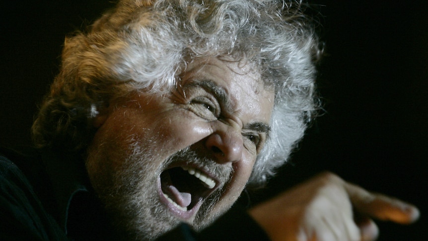 Italian showman Beppe Grillo waves to supporters during an election rally