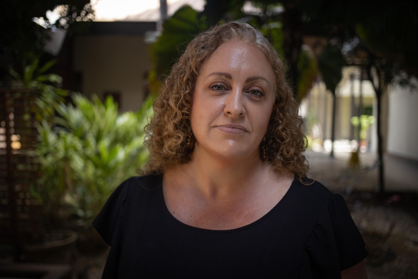 Woman with curly hair wearing a black shirt.