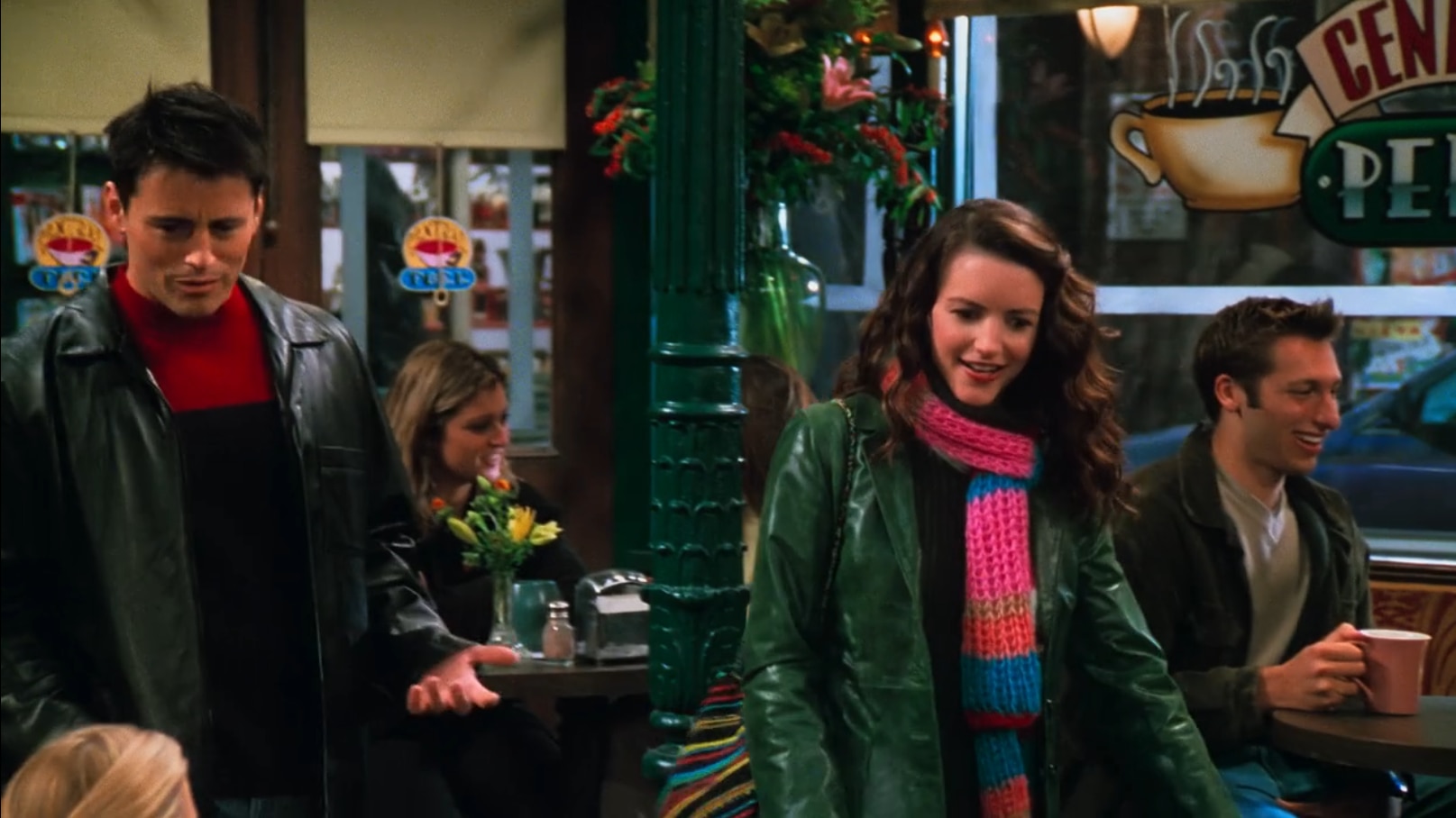 A coffee shop scene from Friends with Joey and his girlfriend in the foreground and Ian Thorpe in the background.