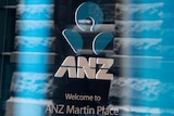 ANZ logo in front of a bank branch.