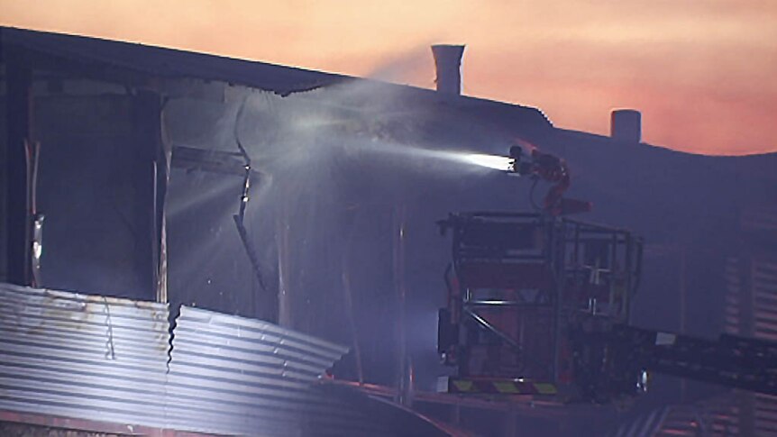 Aerial firefighting device trains water on a school fire.