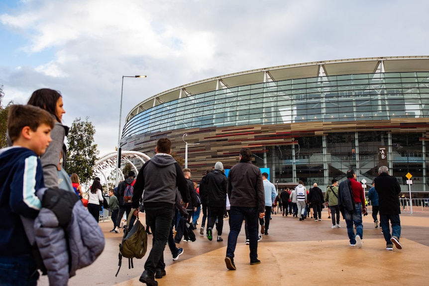 A crowd walks towards Perth Stadium.