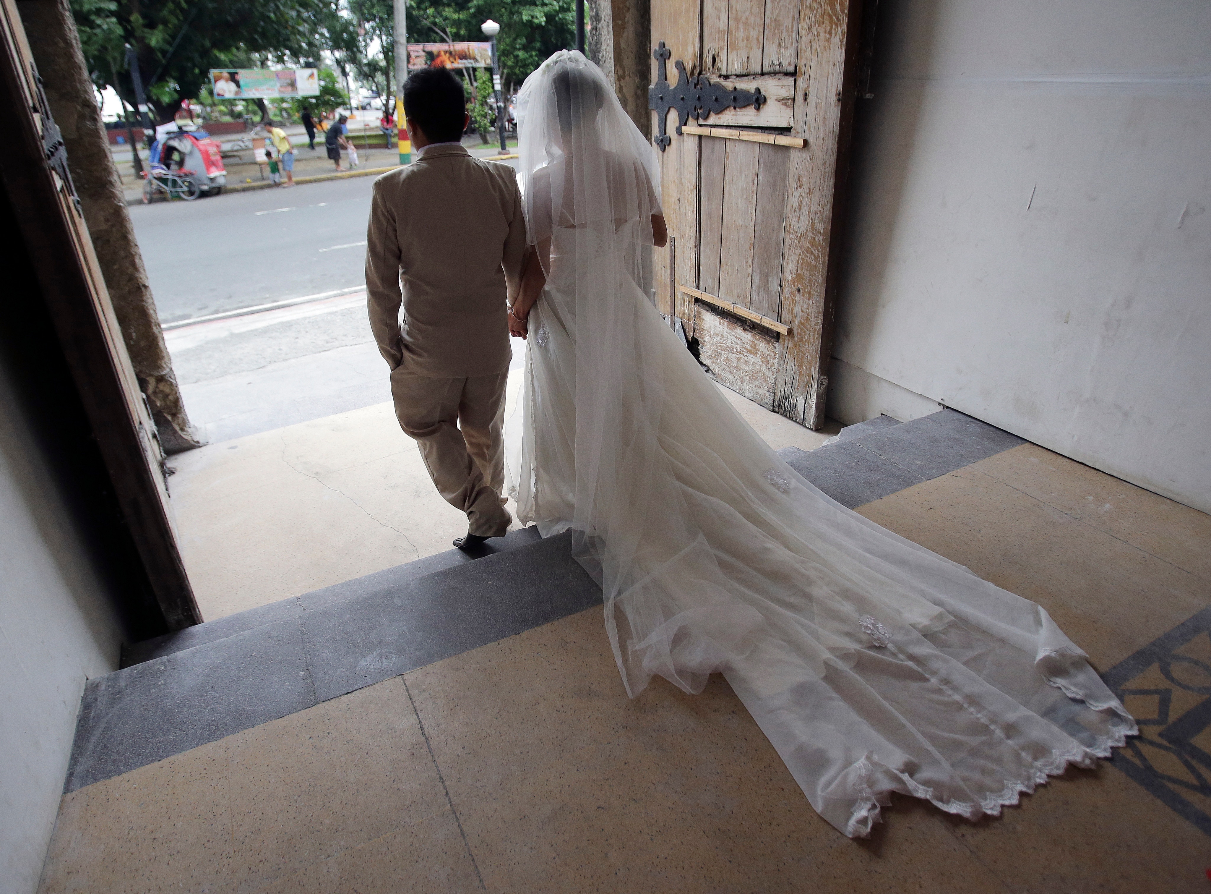 Bride and groom leave the church to the bustling streets of the Philippines
