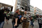 Palestinians carry a wounded man after air strike