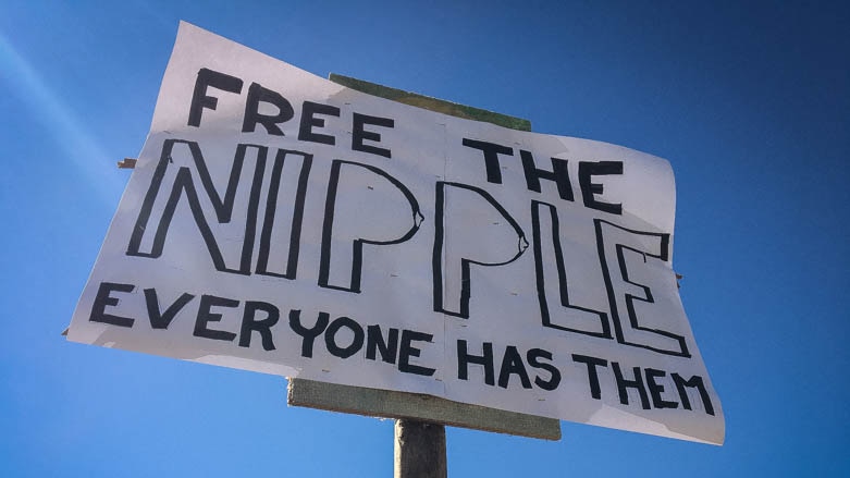 Sign that says 'free the nipple, everyone has them.'