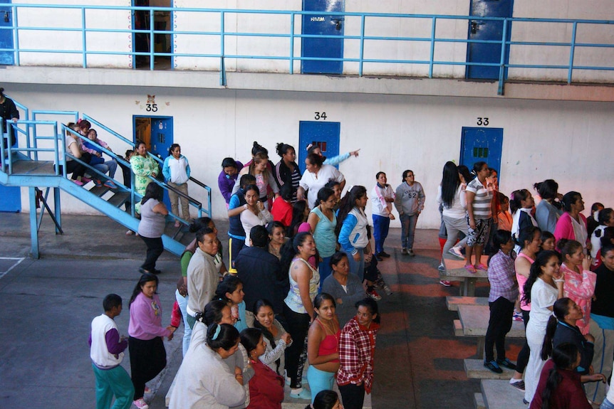 Women stand in a common area inside the El Buen Pastor prison.