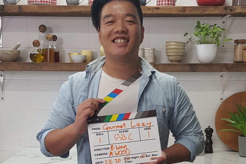 Brendan Wan holds a clapperboard.