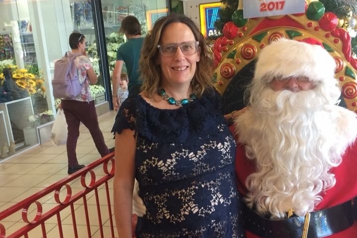 Expectant mum Alina Tooley stands next to a shopping mall Santa