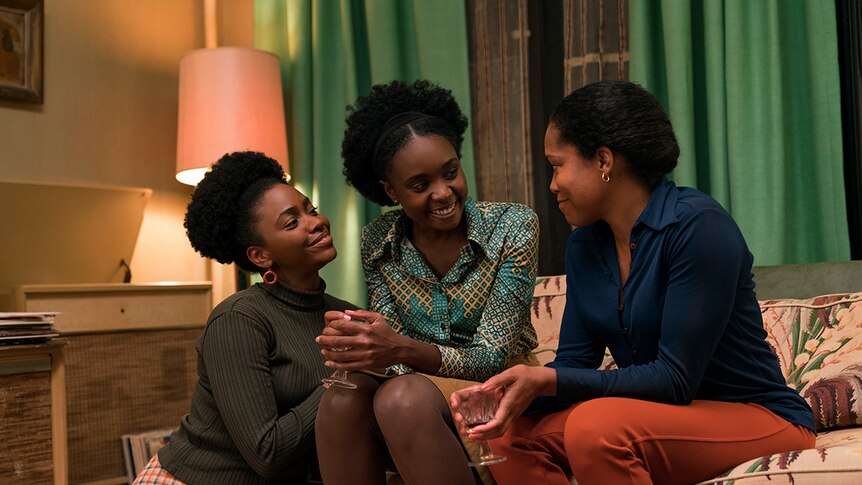 Colour still of Teyonah Parris, KiKi Layne and Regina King sitting together on lounge in 2018 film If Beale Street Could Talk.