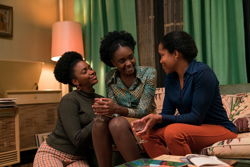 Colour still of Teyonah Parris, KiKi Layne and Regina King sitting together on lounge in 2018 film If Beale Street Could Talk.