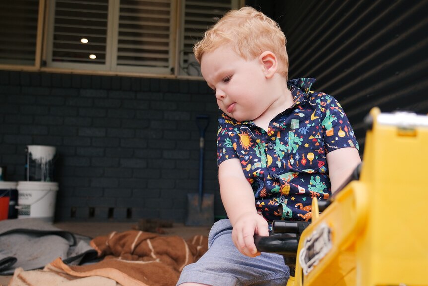 a young boy playing with a toy digger