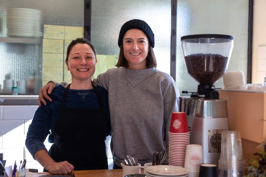 Two cafe owners, Candice and Susannah, stand behind a coffee machine at Jessie's Girl cafe in Brisbane, taken on 24th July 2017