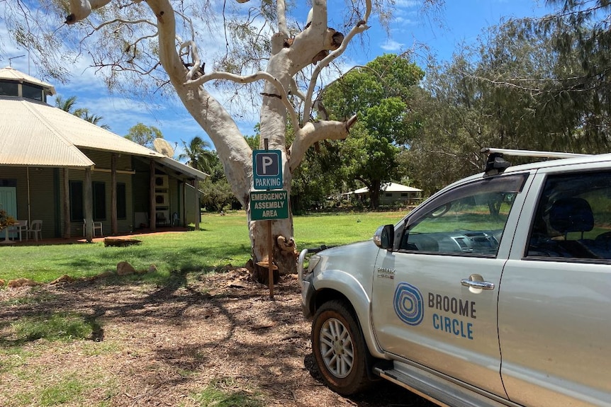 A Broome Circle vehicle parked outside of a building with green grass and a tree nearby.