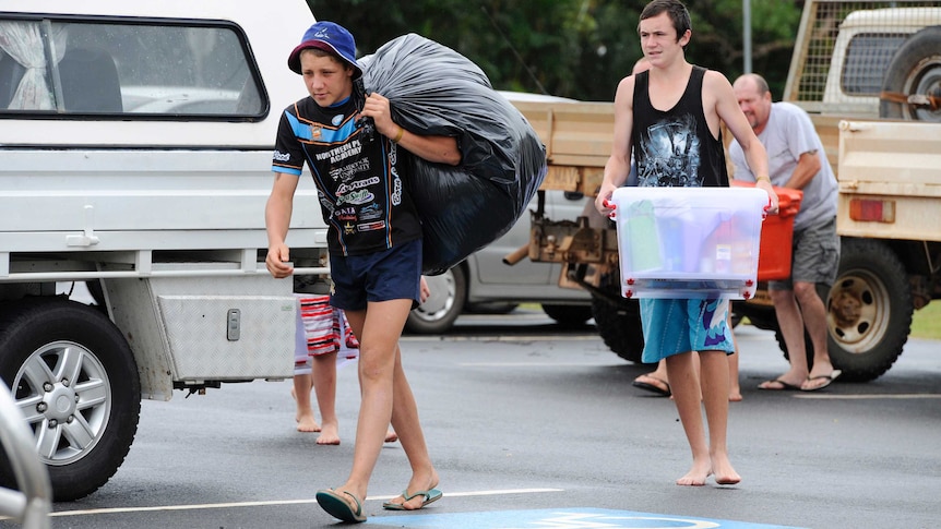 People arrive with their belongings at an evacuation centre in Cooktown ahead of Cyclone Ita