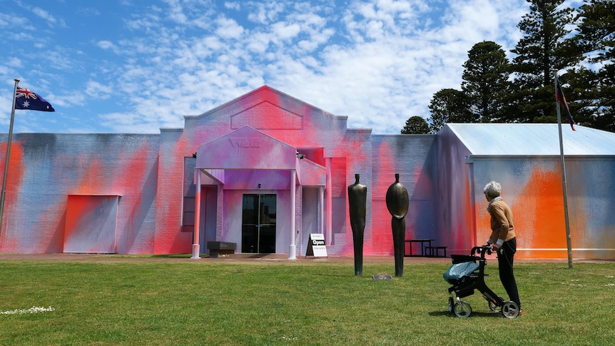 Woman using a walking frame stops to take a look at the Warrnambool Art Gallery.