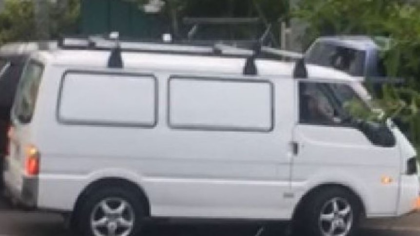 A police handout of a white van with mag wheels and roof racks.
